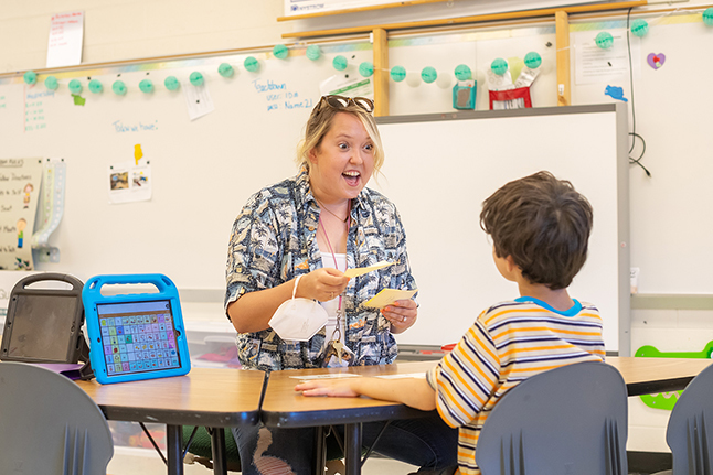 A teacher works with a student