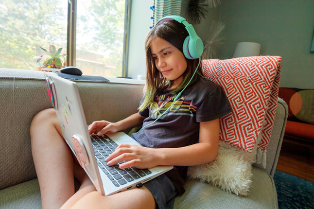 Child with headphones and working on laptop