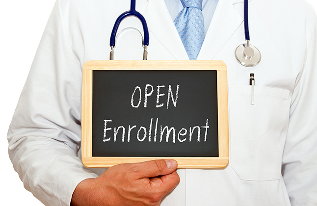 Doctor holding a sign that says Open Enrollment