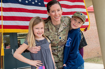 Military family in front of American flag
