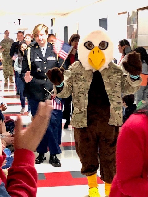Ernie the Eagle, wearing military clothes, leads the High Five for Heroes parade through Clermont's halls during the Veterans Day event.