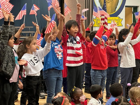 Students singing and waving American flags