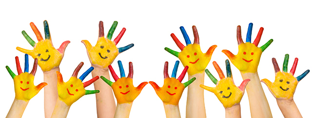 Painted hands in the air featuring happy faces drawn on them. 