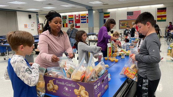 Parents and students packing food donations