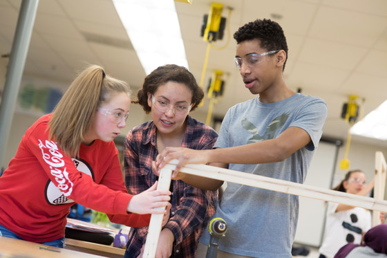 Image of students collaborating and applying geometry to build a greenhouse.