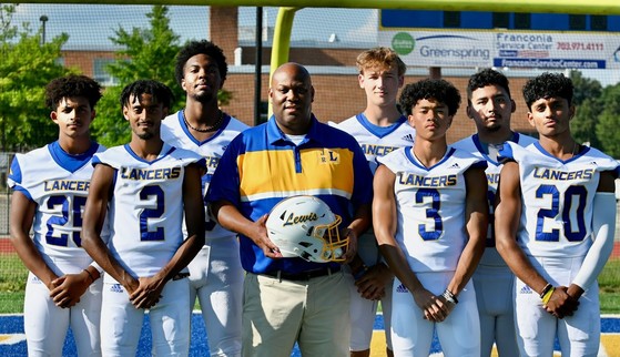 football coach posing with players