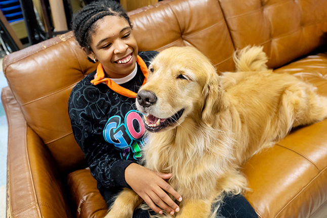 Student sits with therapy dog