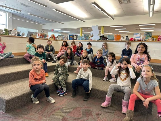 An image of kindergartners during a read aloud in the library pit. 