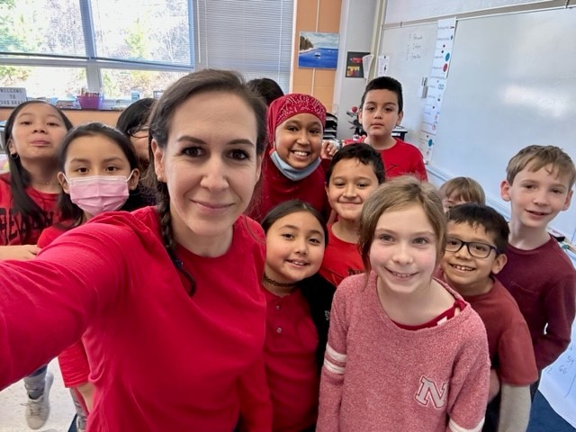 A teacher and students wear red shirts. 
