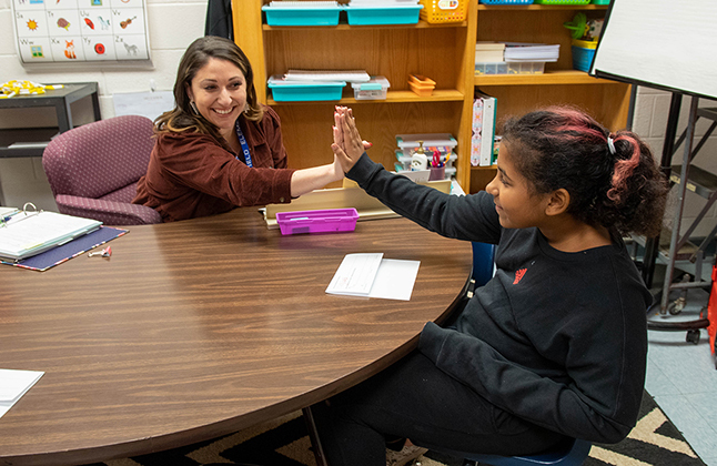 teacher high fiving student