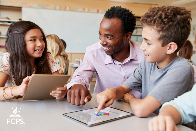 Teacher helping students with their ipads