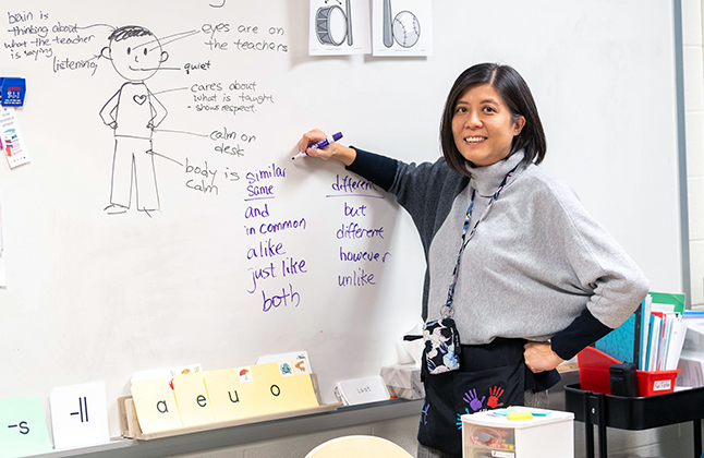 Teacher smiling at whiteboard