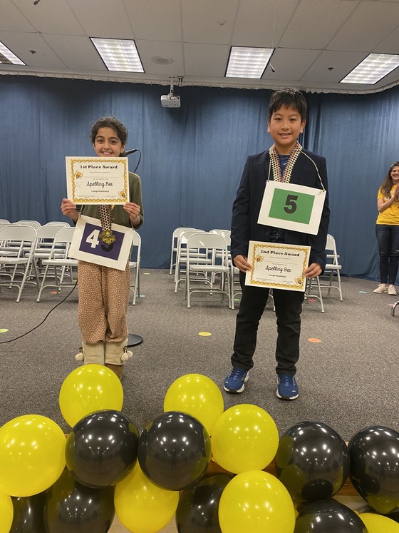 Two spelling bee winners pose with awards