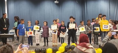 participants in the spelling bee posing onstage