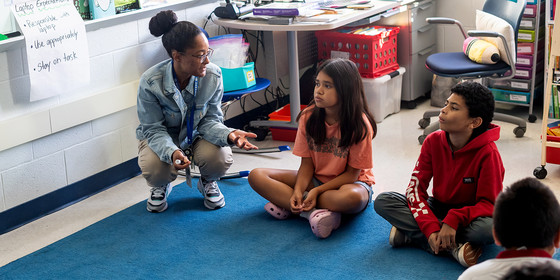 Teacher with students in sitting circle