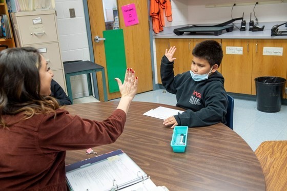 Teacher and student high-fiving