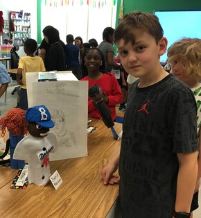 Students showing off projects about famous Americans