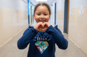 Student holding up "hand heart"