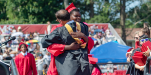 student hugging administrator during graduation