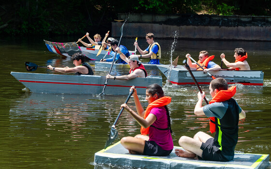 students racing boats in a river