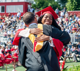 student hugging administrator at graduation