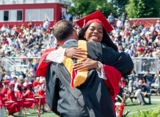 student hugging administrator at graduation
