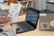 teacher working with student on laptop