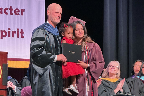 student receiving diploma on stage at graduation