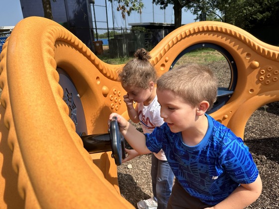 Two students play on new playground equipment