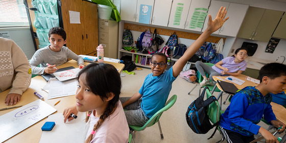 student raising hand in classroom