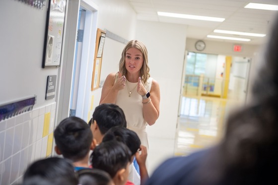 teacher helping students stand in line