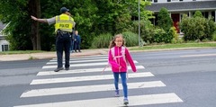 Student walking on crosswalk with police officer