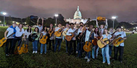 Students holding guitars standing in front of U.S. Capitol