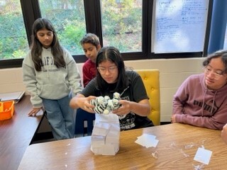 students test out the stability of their tower