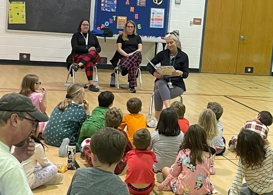 Teacher reading to students in the gym