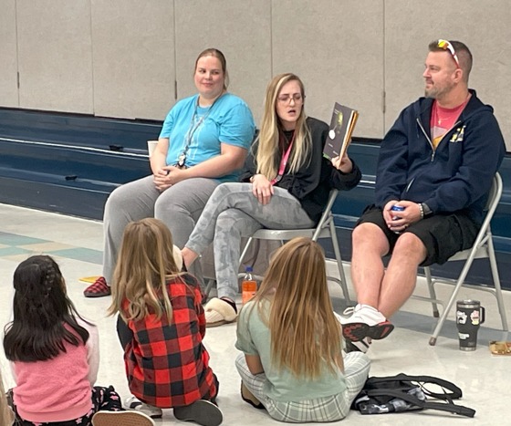 Teacher reading to students in the cafeteria