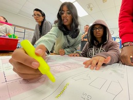 Holmes Middle School Student and a highlighter marking the key on the map of fictitious Tinseltown.  