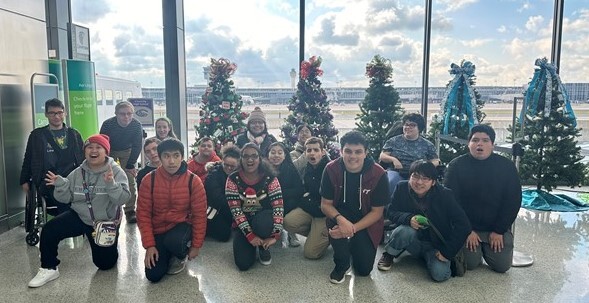 Chantilly High School STEP students posing in front of Christmas trees at Washington Dulles International Airport