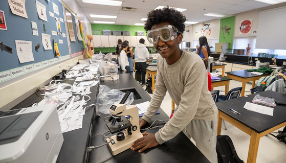 A student uses a microscope in Biology class at McLean High School.