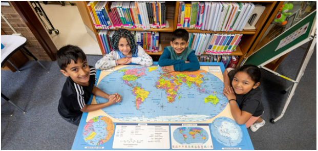 Students pose around world map