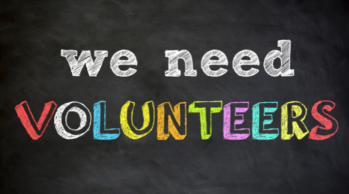 Multicolored letters on a black background with the words "WE NEED VOLUNTEERS"