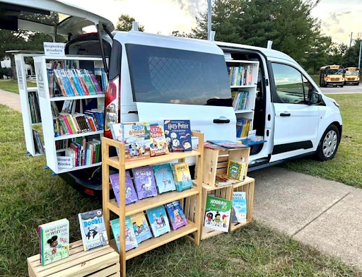 An image of a white van with shelves of books for sale. 