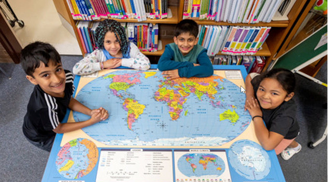 Students working around a table with a world map