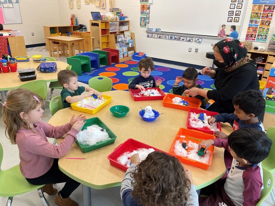 Preschoolers playing with snow on trays