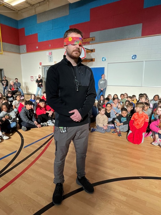 PE teacher, Scott Conner, is blindfolded for an activity during the school-wide morning meeting. 