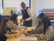 Students working with legos as teacher looks on