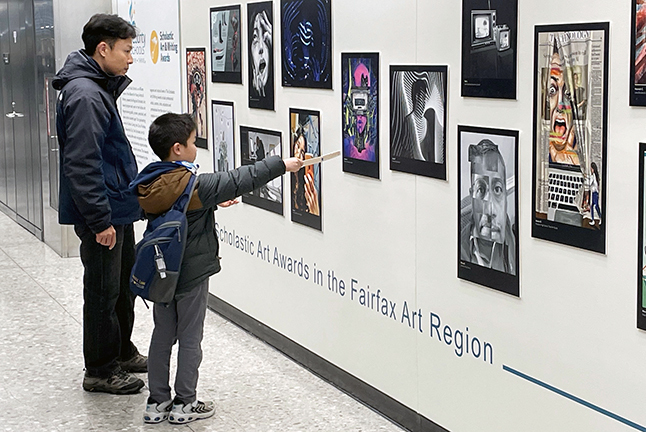 Parent and child viewing FCPS student art at Dulles International Airport as part of the Airport Authorities Youth Art Walk.