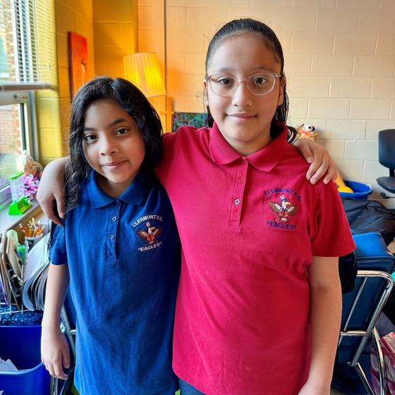 Two students pose in Clermont polo shirts. 