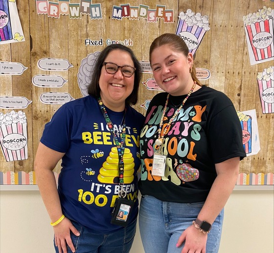 Two teachers wearing 100th Day of School shirts