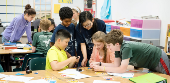 students work together at a table on a science lesson